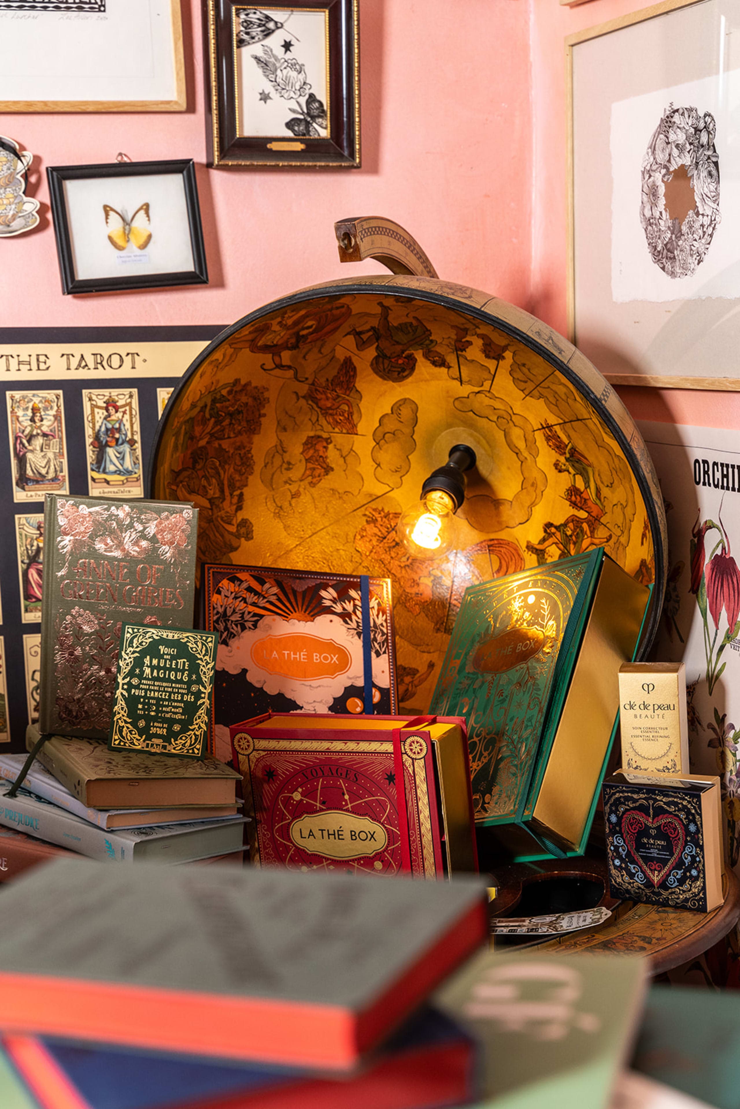 スタジオの机。ボタニカルレファレンス本が積み重ねられ、ビンテージ風タスクランプが置かれている